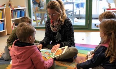 Grundschullehrerin übt mit Kindern das Lesen mit Silbentrennung