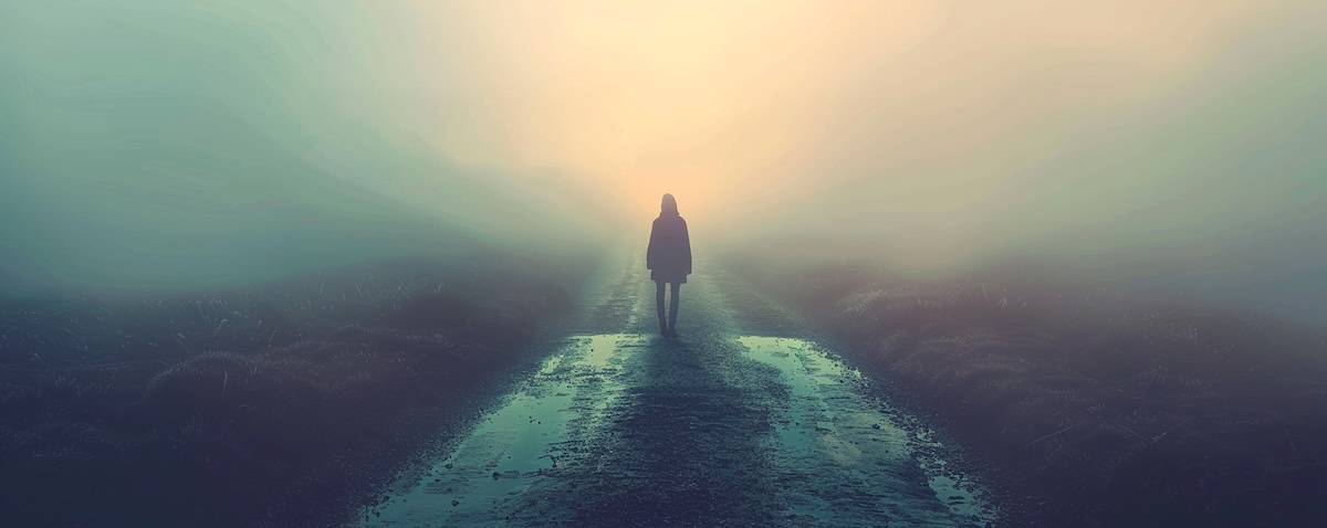 Person an einer Weggabelung im Nebel als Sinnbild für eine Identitätskrise
